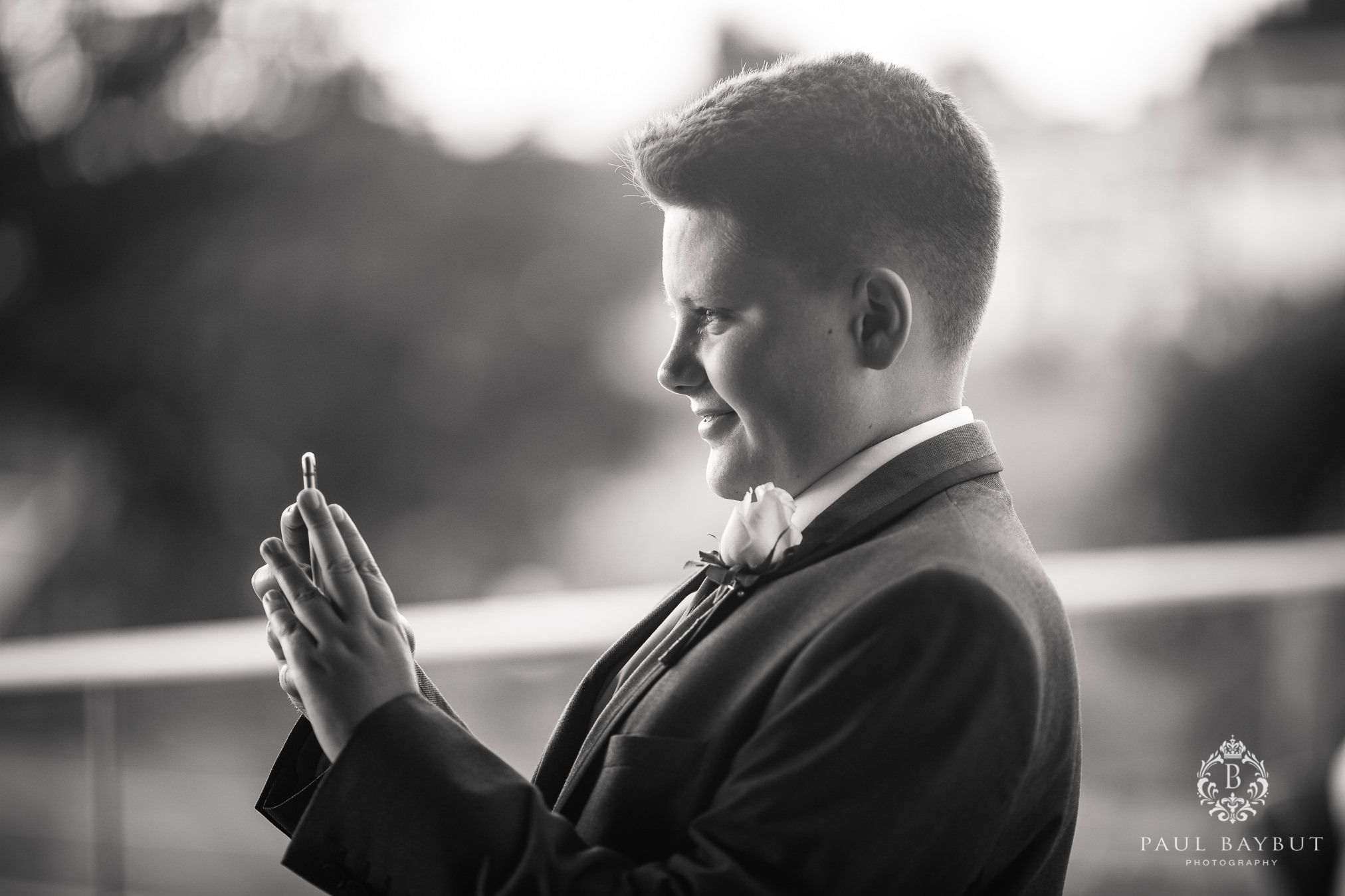 Side profile silhouette of person in formal attire looking at phone.