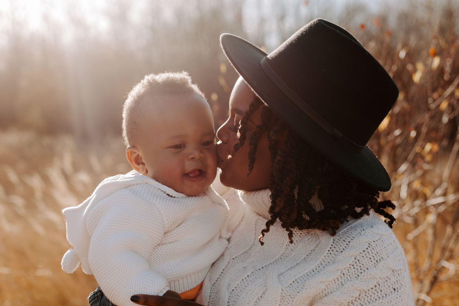 Black mom kissing her baby
