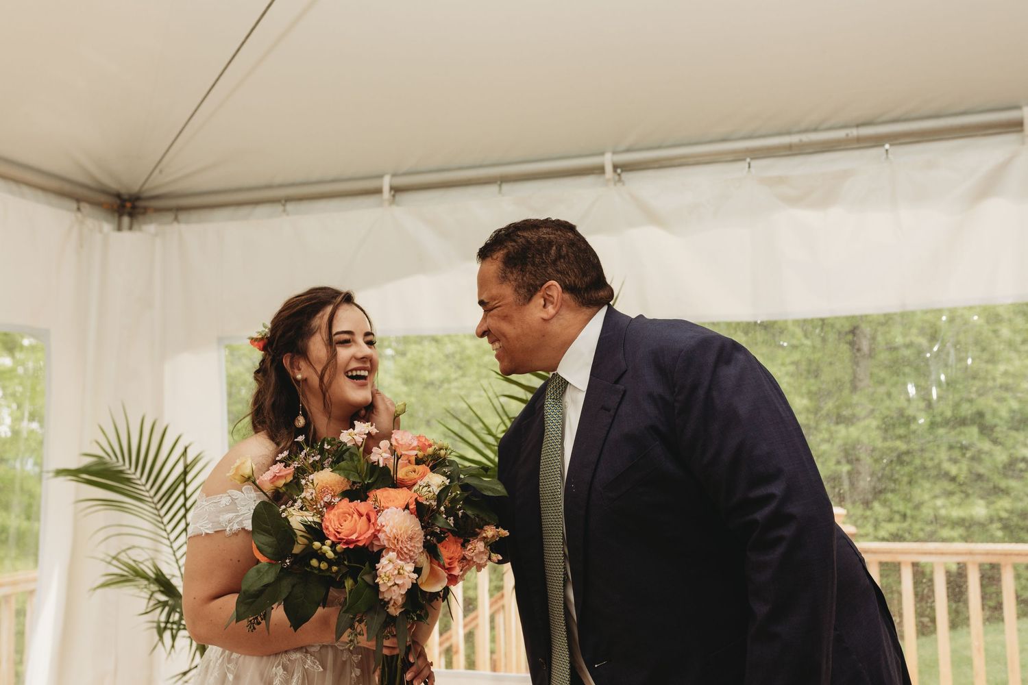 An emotional moment shared during a wedding celebration with peach-colored floral bouquet.