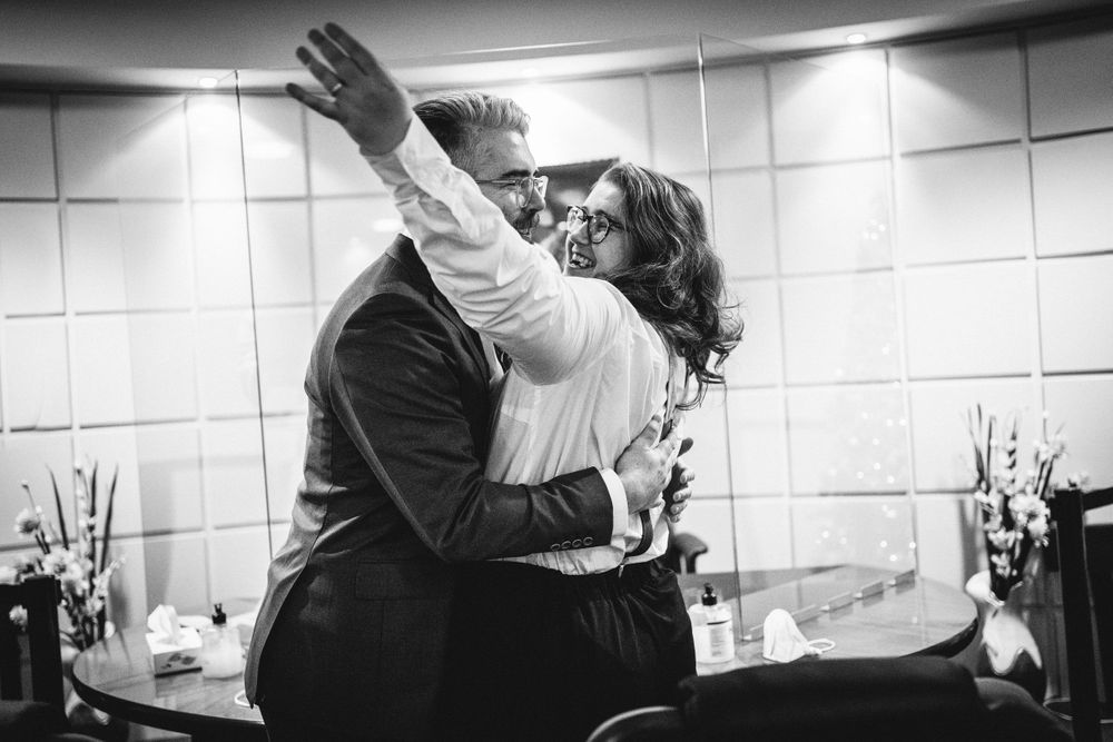 A couple embraces in an emotional moment during what appears to be a wedding ceremony.