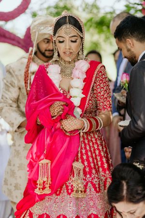 Traditional Indian wedding attire featuring detailed embroidery and jewelry during ceremony.