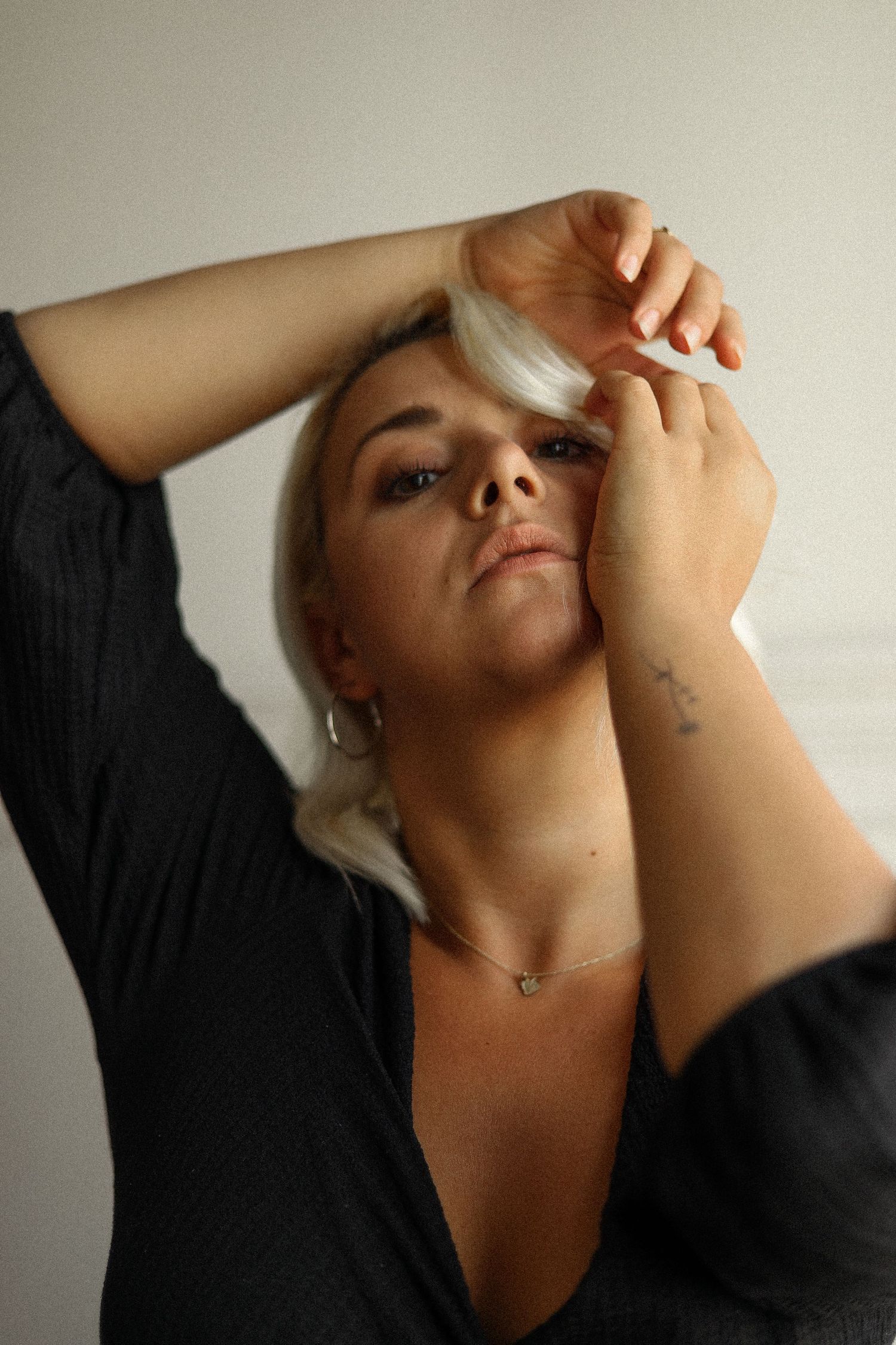 Artistic portrait of woman in black top with dramatic pose.