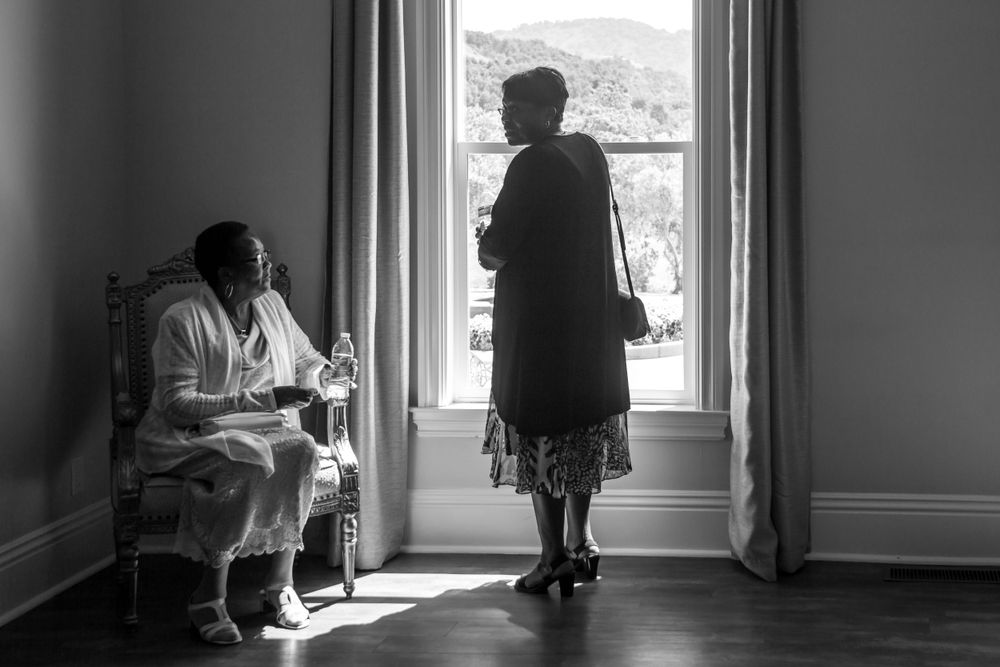 Black and white photo series showing silhouettes of people standing by windows in an empty interior space.
