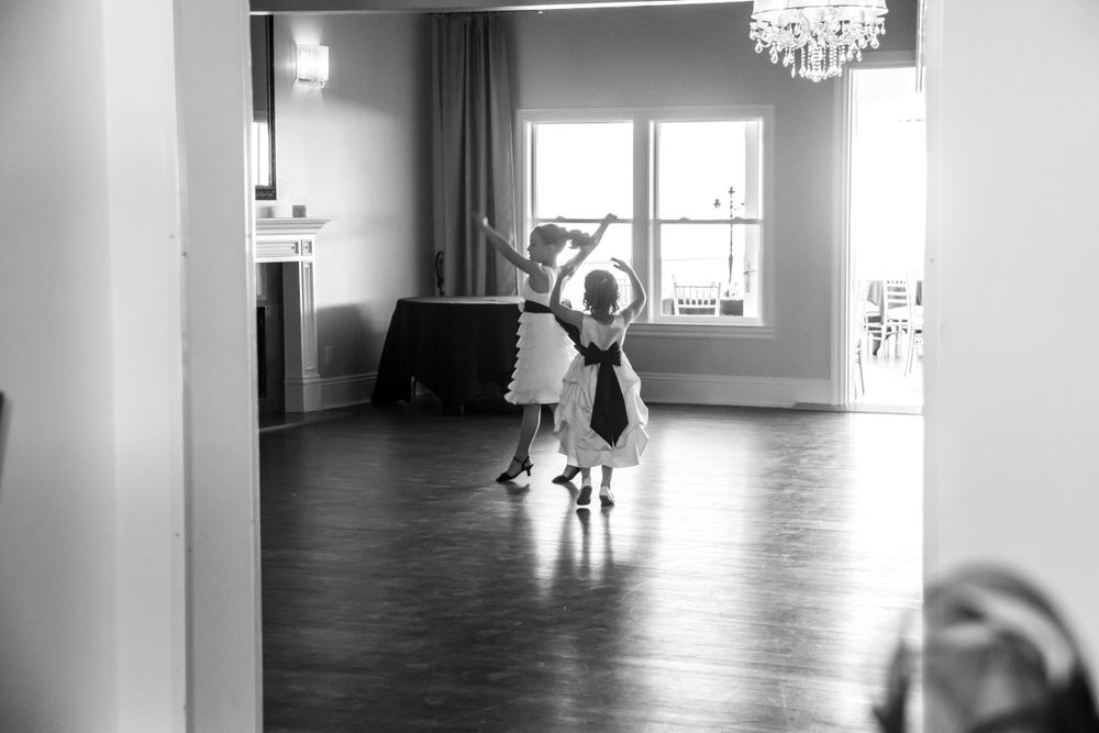 A dancer in a flowing dress practices ballet moves in an elegant studio with hardwood floors and natural light.