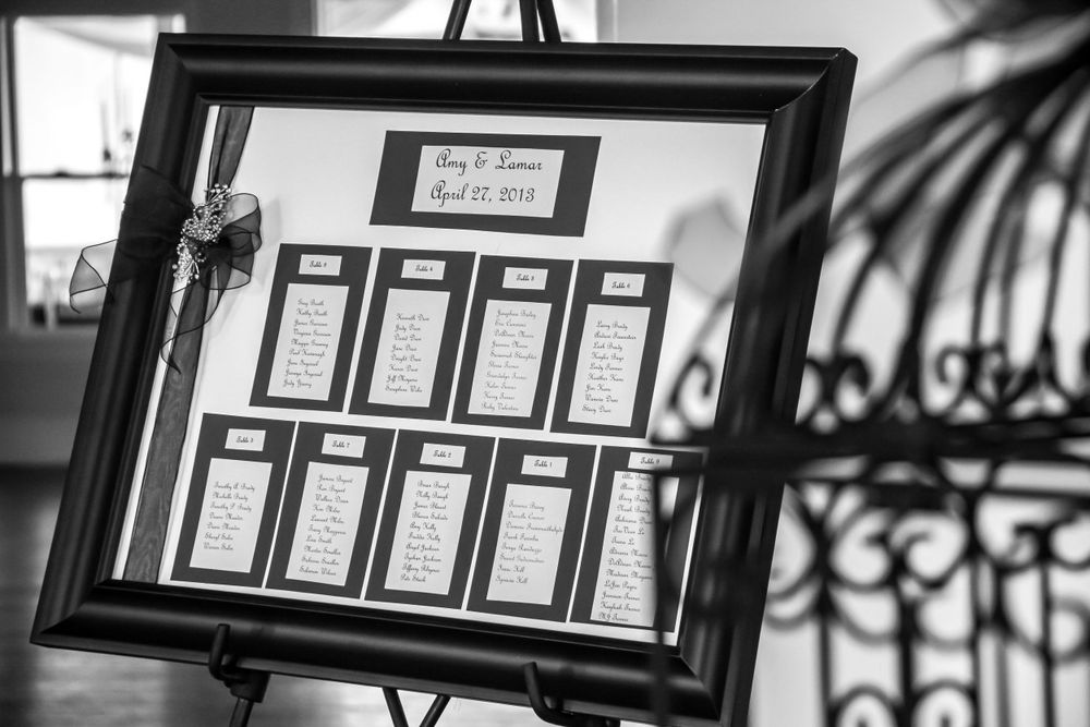 Black and white framed photographs hang on a wall in a gallery-style display showing a series of artistic images.