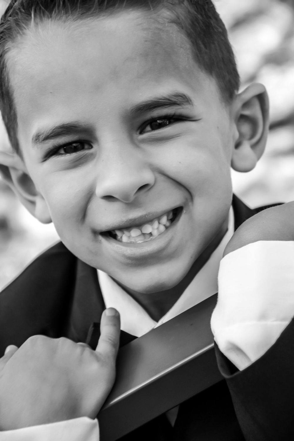 Black and white portrait sequence showing four candid smiling expressions in a progressive series.