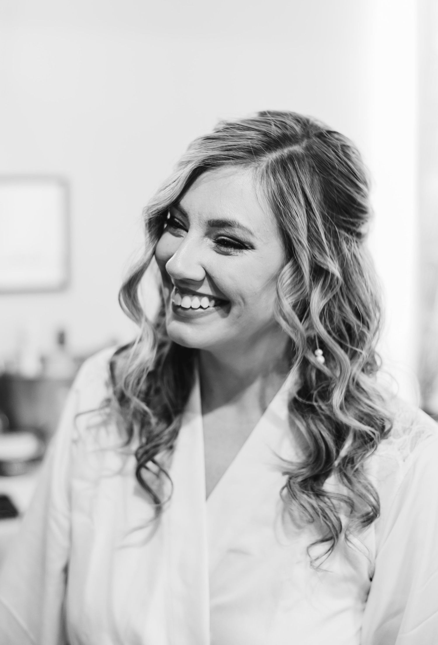 Black and white portrait of someone laughing in a white robe.