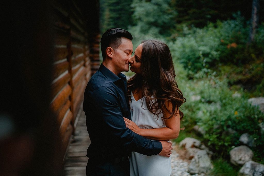 Couple in coordinated outfits dancing together on a forest path.