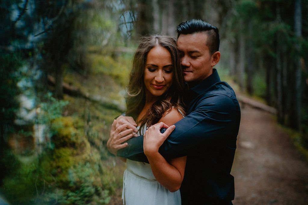 Romantic forest photoshoot with couple dancing on a dirt trail.