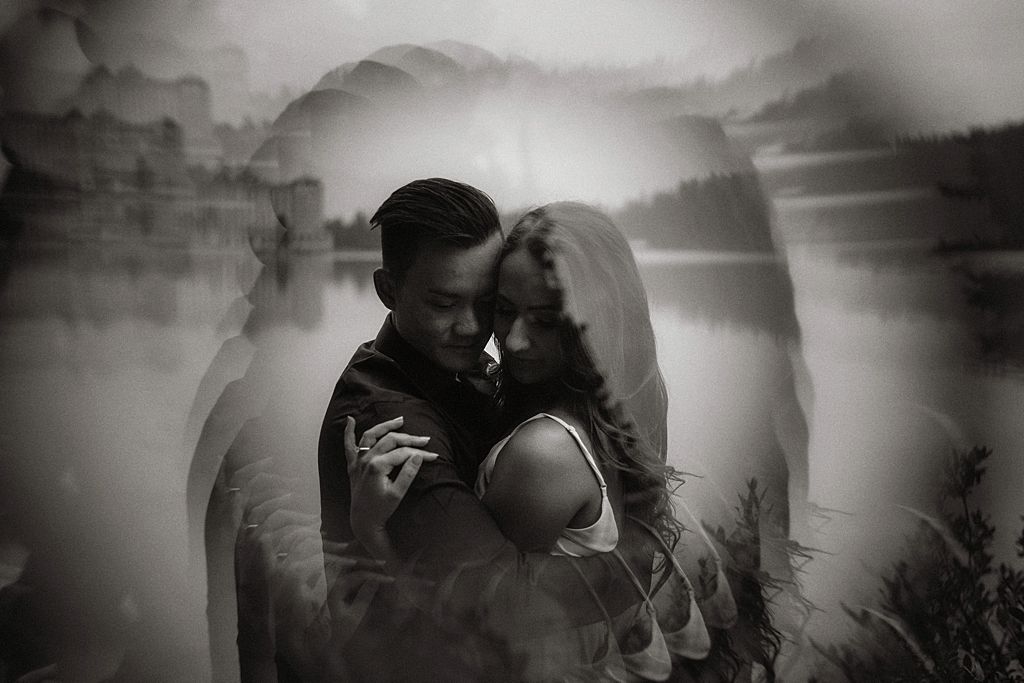 Dreamy black and white portrait of couple by a misty lake.
