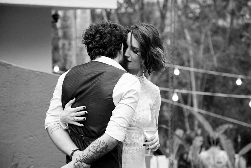 Black and white romantic moment captured during an outdoor wedding celebration.