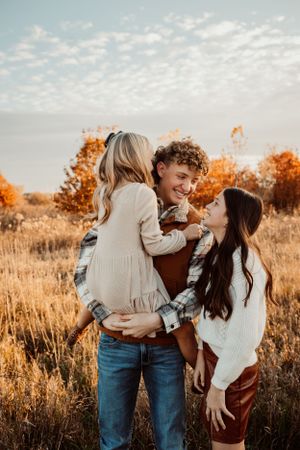 A joyful outdoor family photoshoot captures candid moments at sunset.