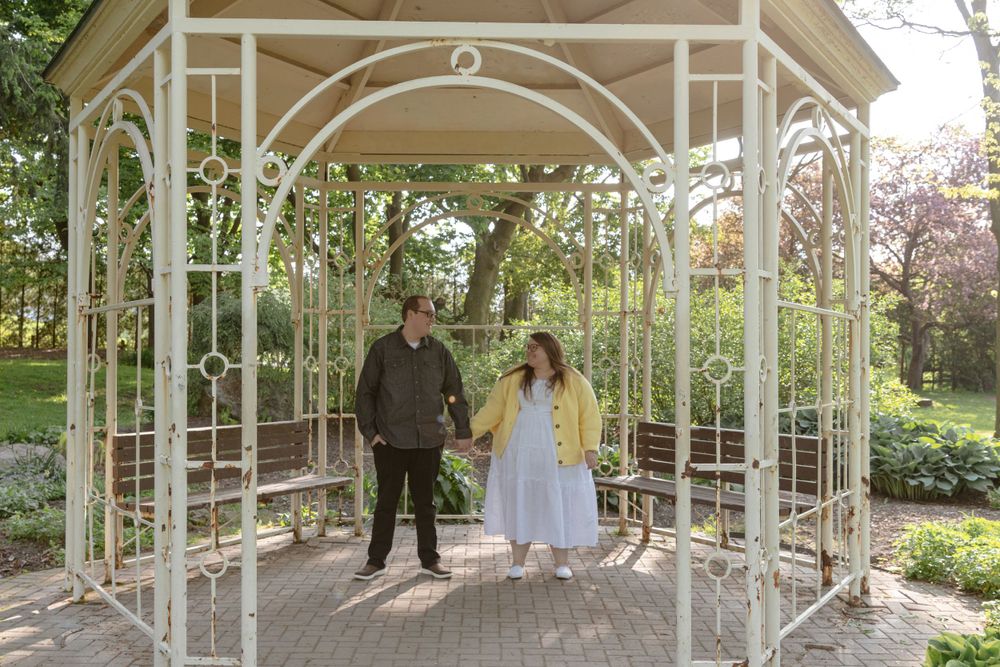 A couple dancing under a gazebo in a park.