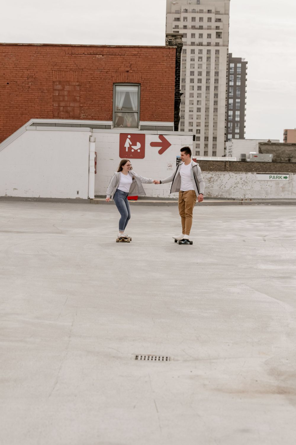 Two people on skateboards in a parking lot.