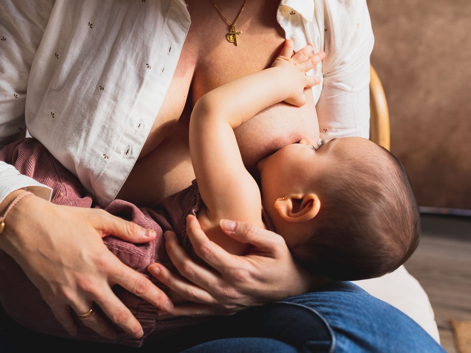 Close-up shot of nurturing moment between parent and infant in natural lighting.