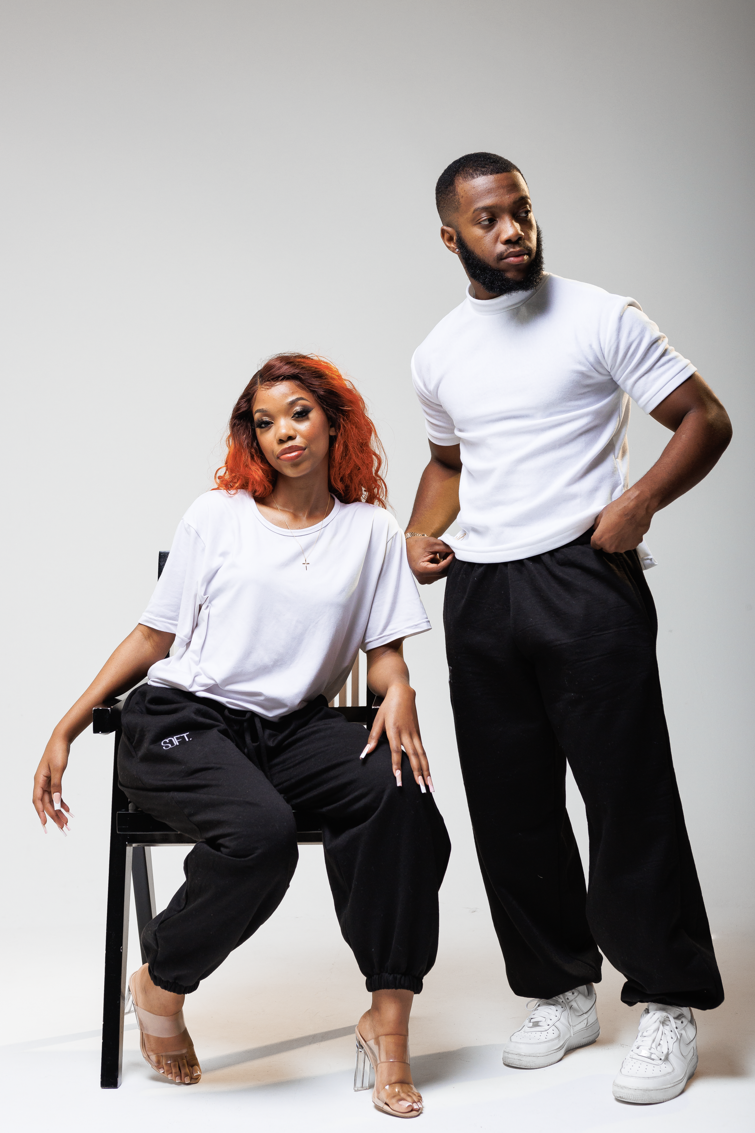 Two models wearing coordinated athleisure outfits pose together against light background.