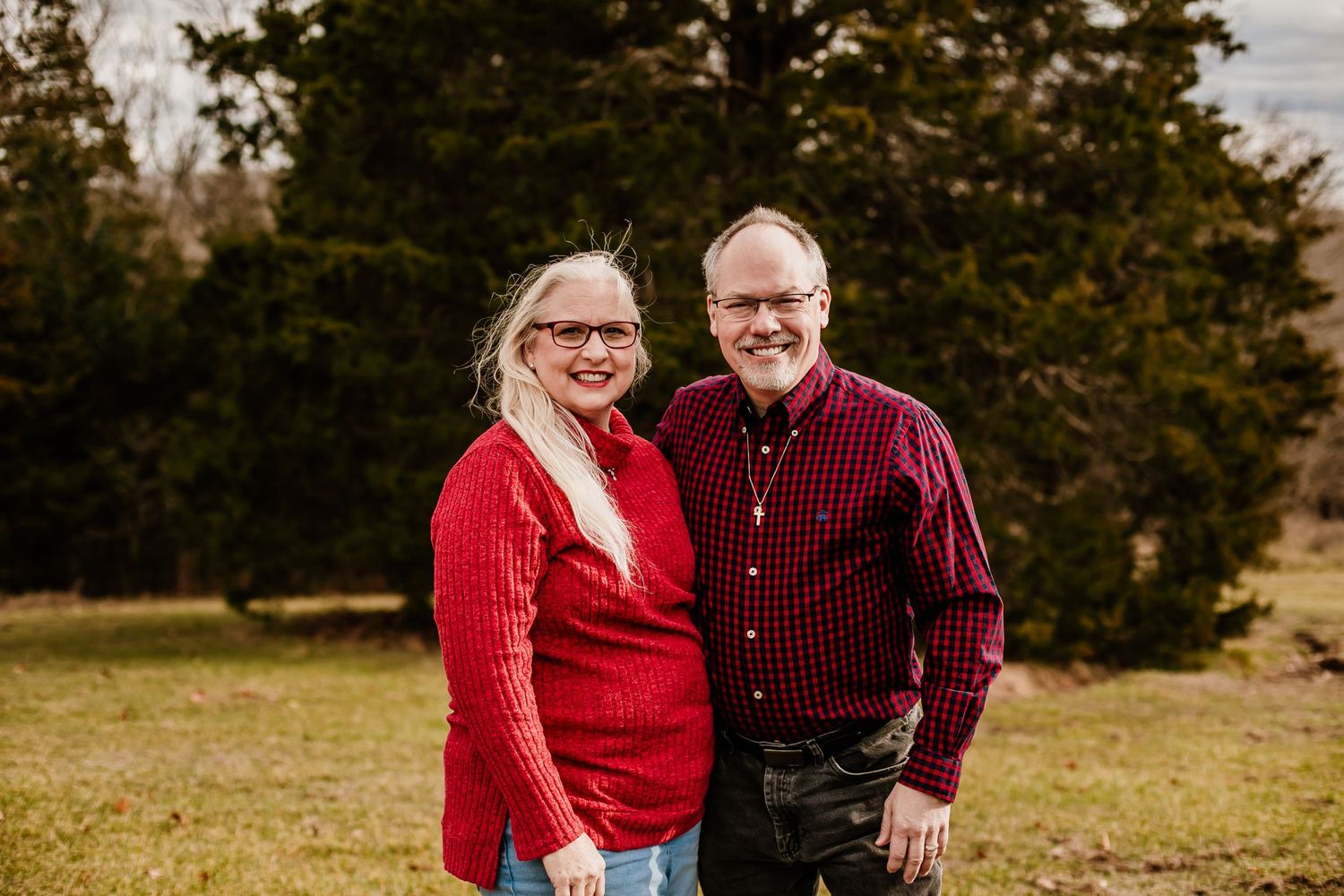 Outdoor family photo session in autumn with coordinated burgundy and black outfits.