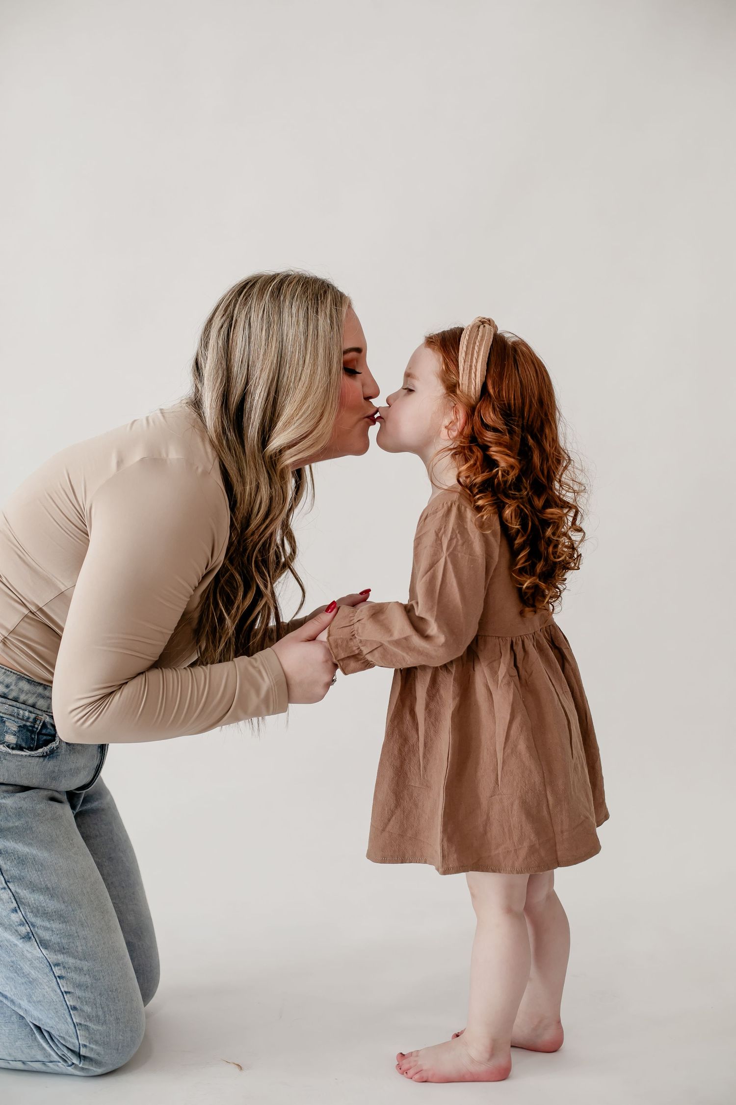 Sweet moments of connection and play in a minimalist white studio setting.