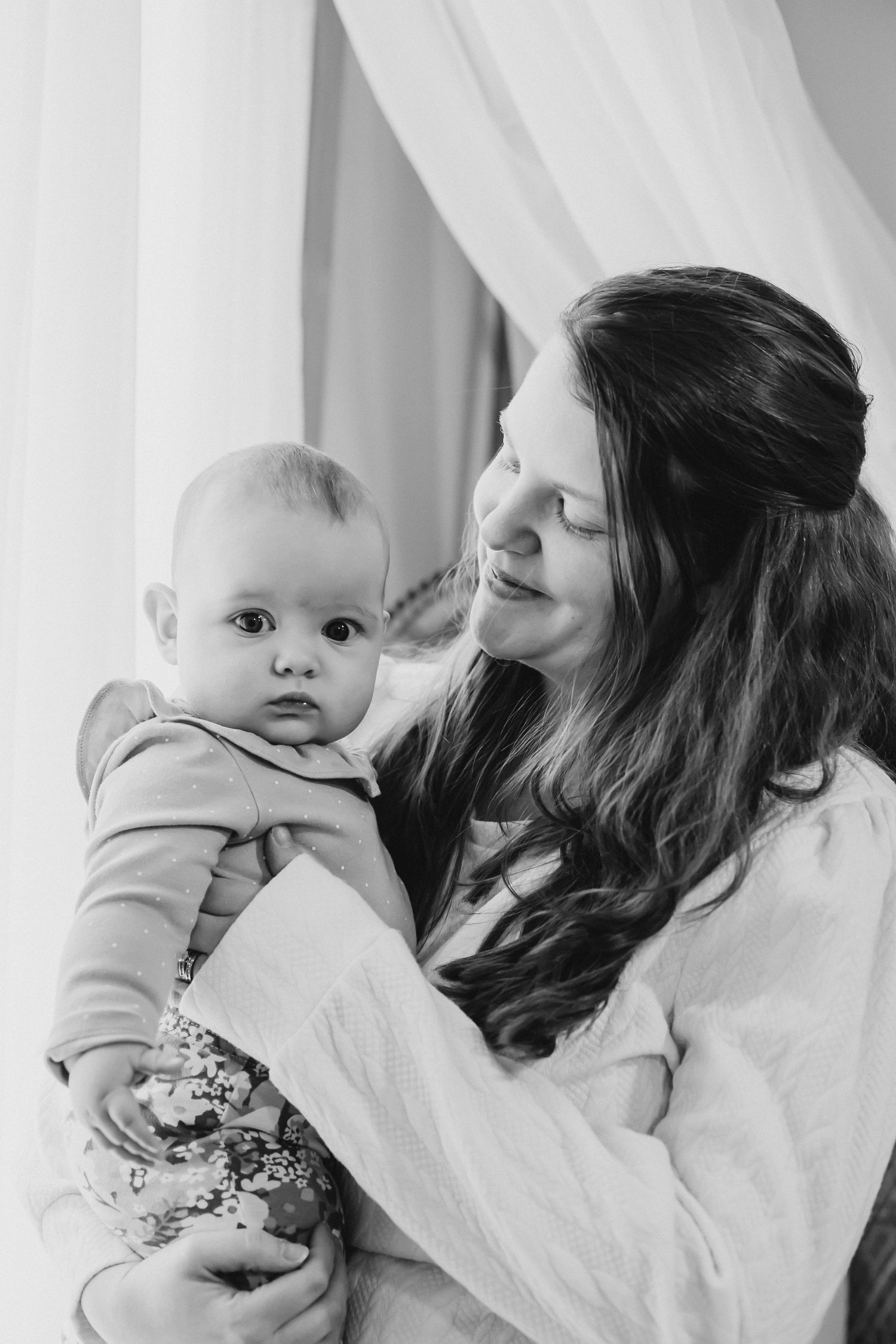 Intimate black and white portraits showing gentle moments with an infant.