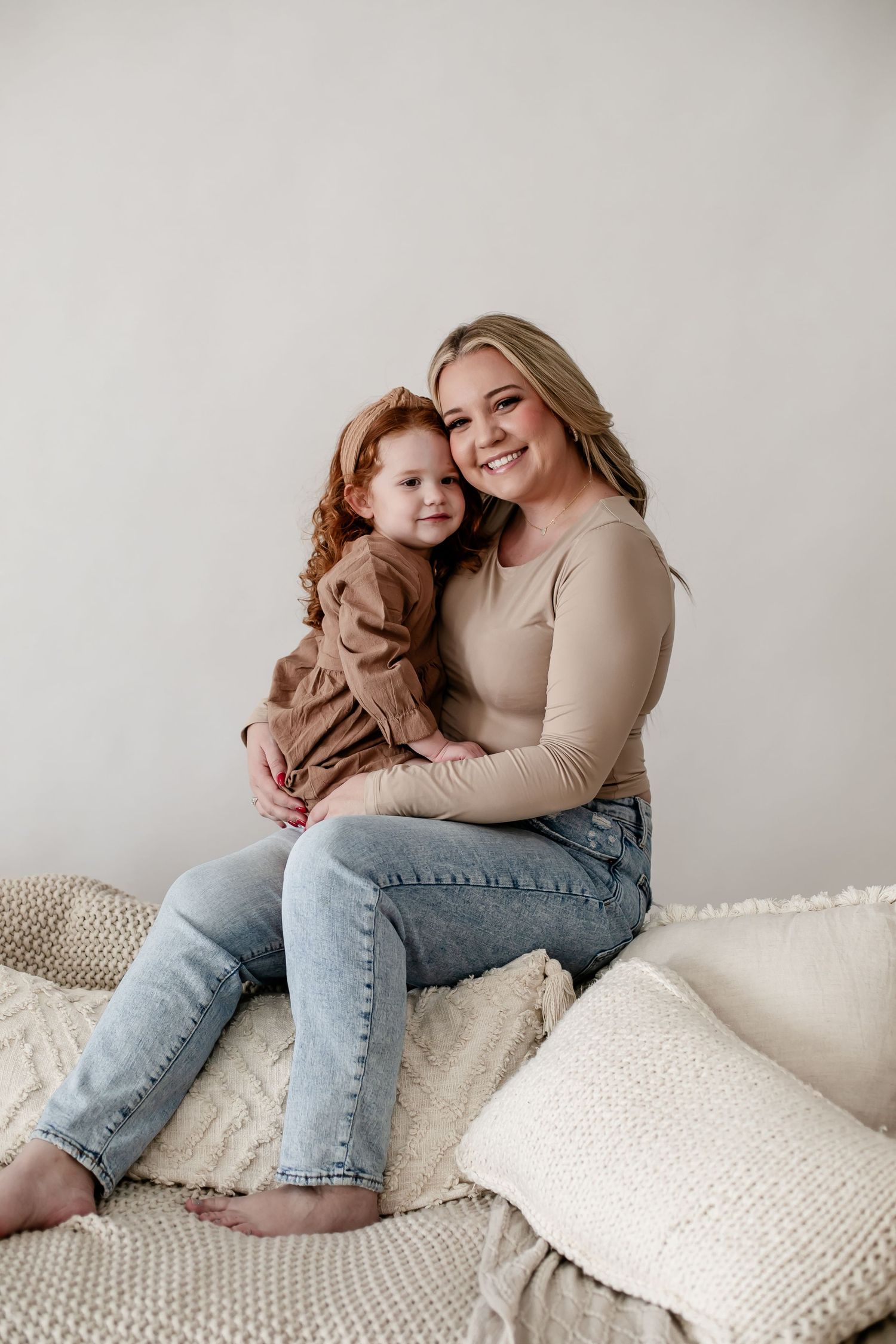 A heartwarming moment of playful interaction on a couch with cream-colored pillows.