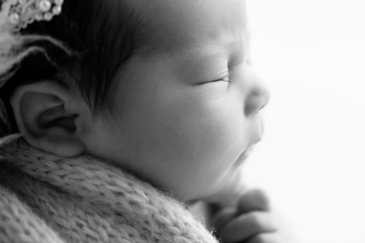 Minimalist black and white portrait of sleeping infant in soft focus.