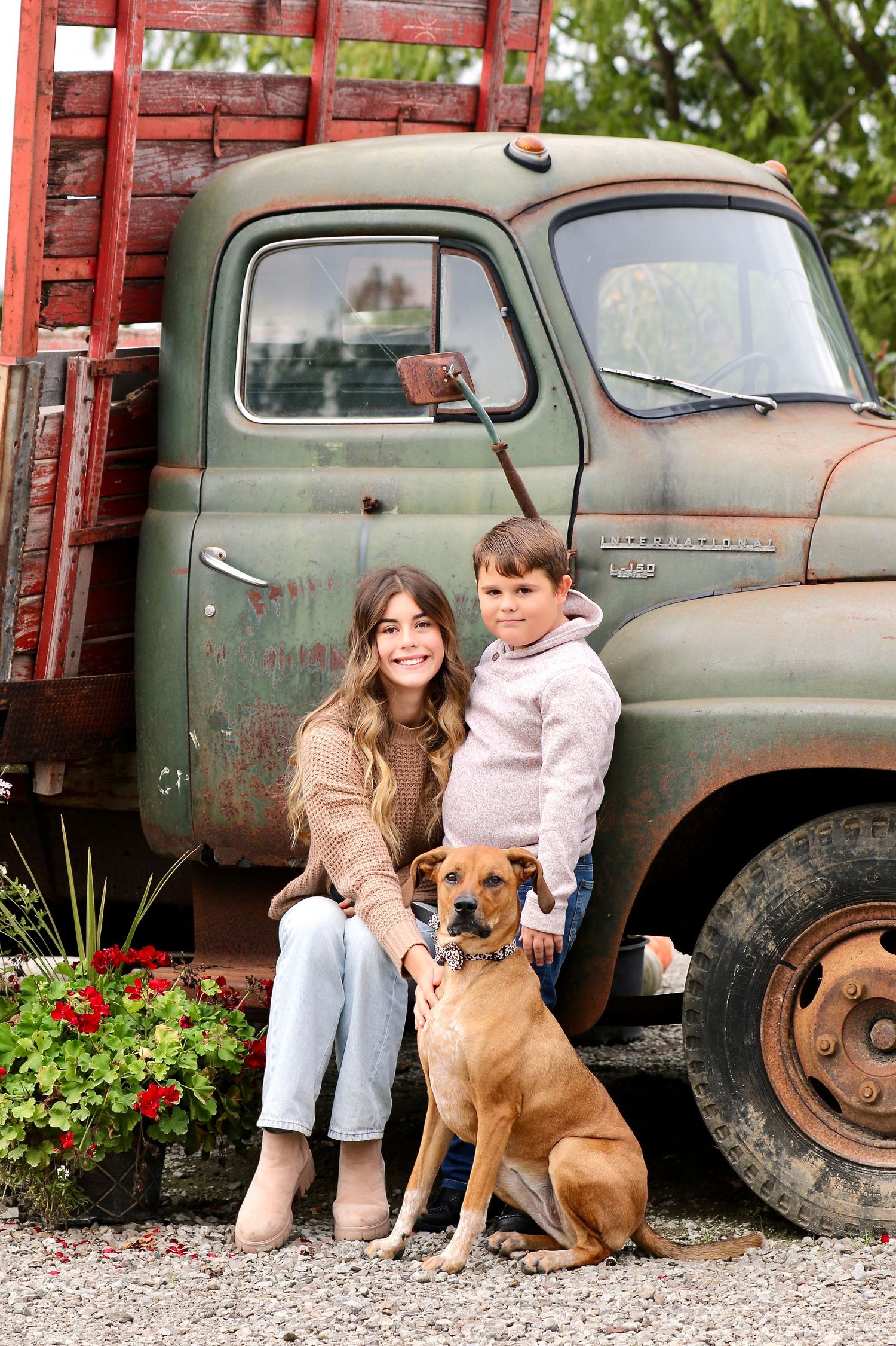 Brother, sister and dog standing by truck at Broadview Landscaping and Nursery, Inc.