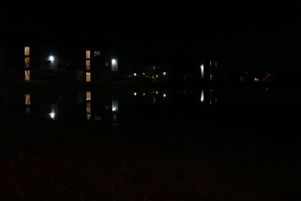 a reflection of lights on a lake at night
