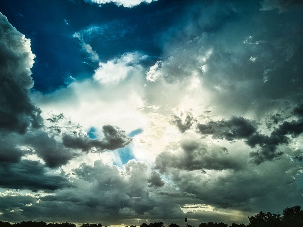 a bunch of clouds with the sun breaking though