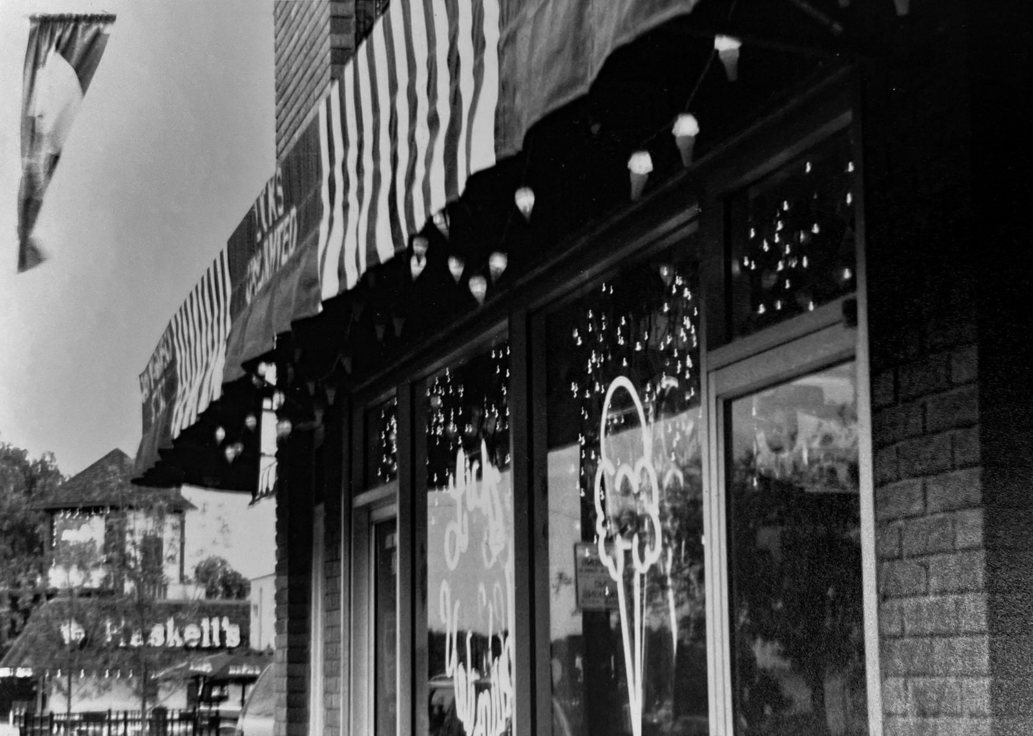 Black-and-white film photograph of small ice cream shop window