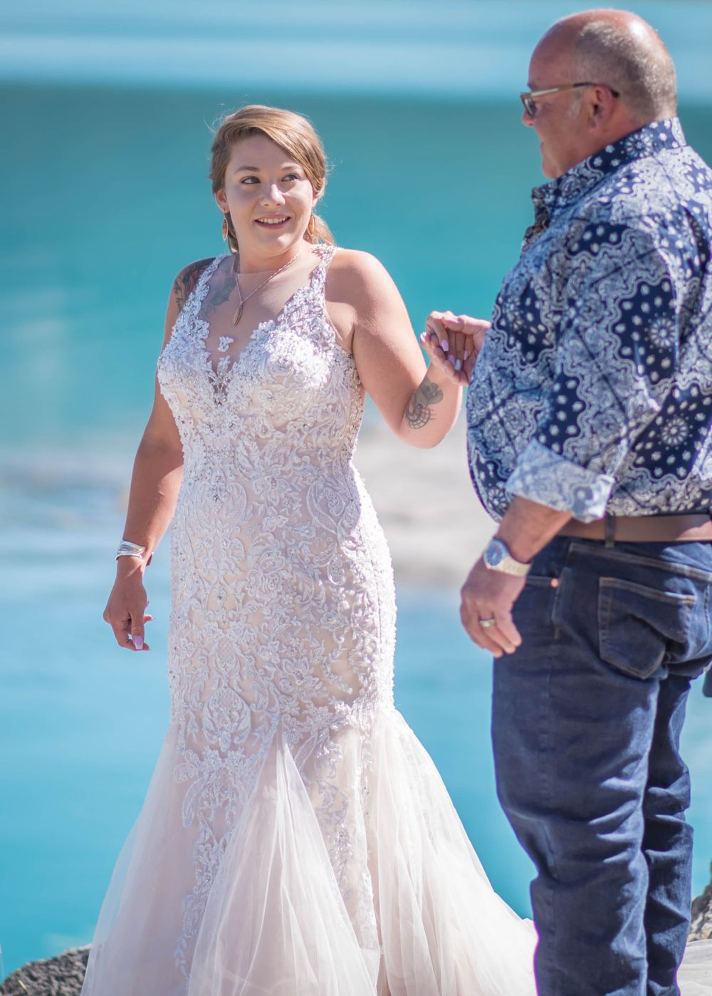 A wedding moment captured against the backdrop of turquoise mountain waters.