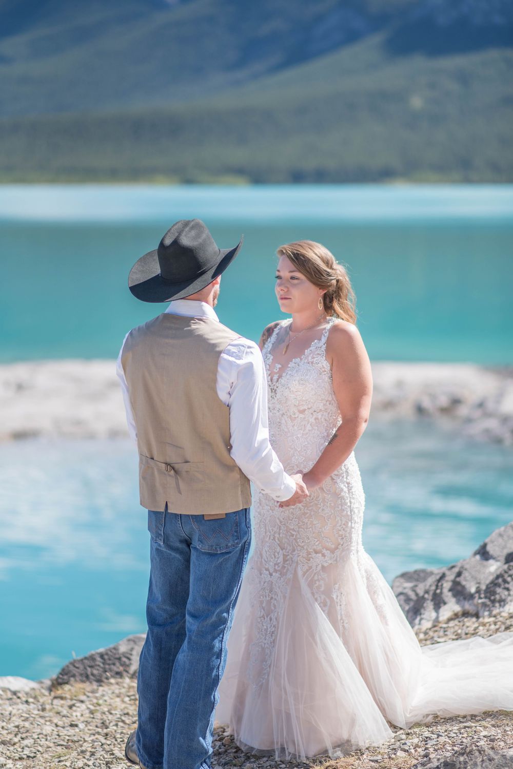 A wedding ceremony moment captured against majestic mountain and lake scenery.