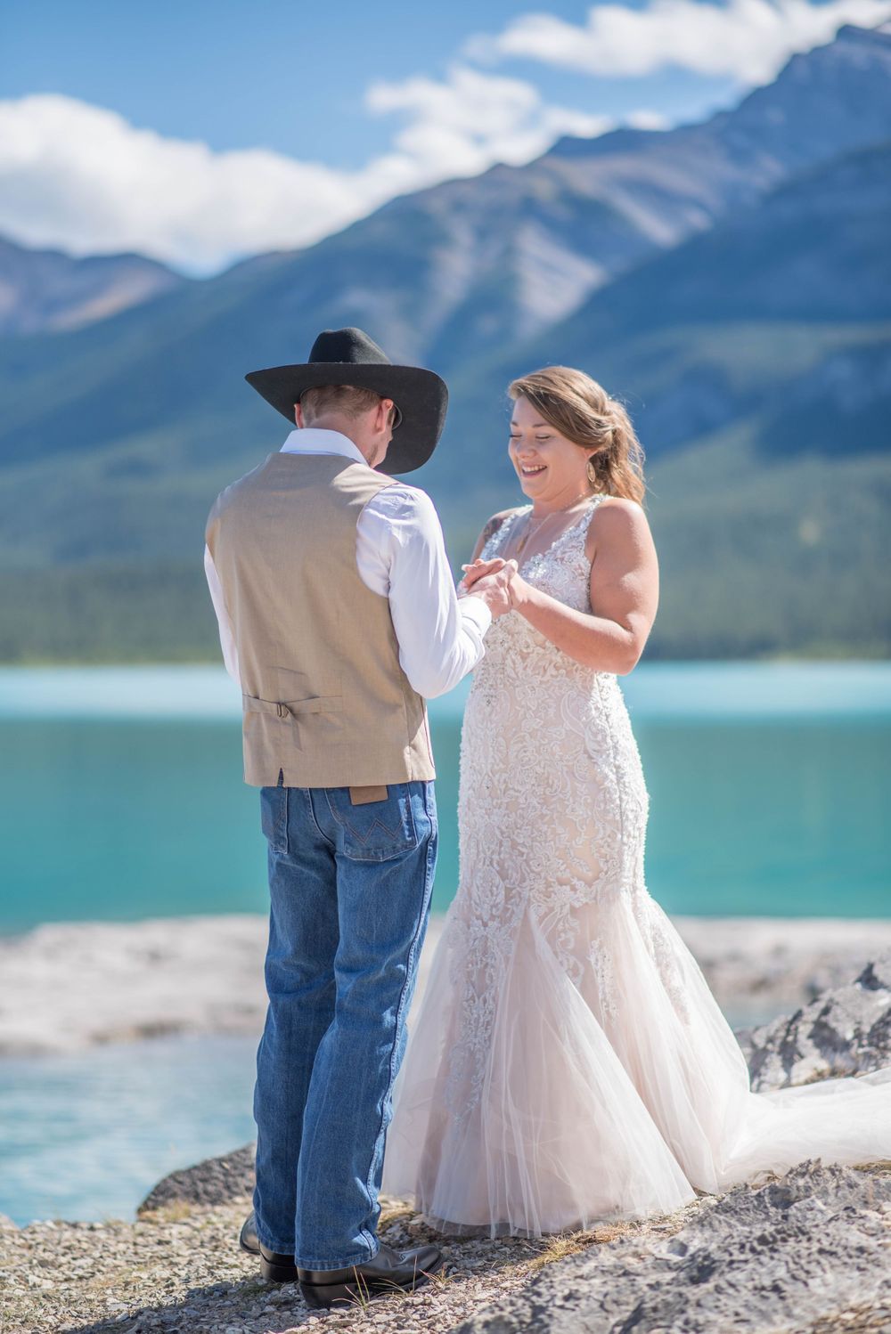 An intimate exchange of vows with dramatic mountain peaks and turquoise waters in the background.