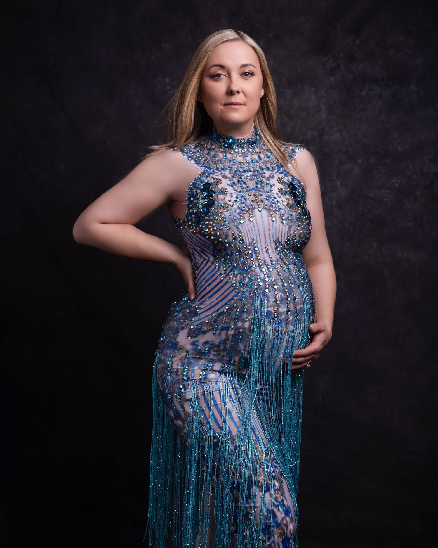 Glamorous portrait featuring a sparkling blue beaded gown against a dark background.