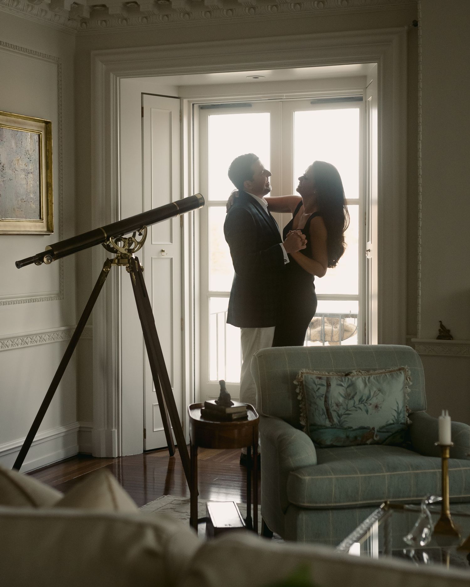 Artistic image of couple in apartment with a vintage telescope