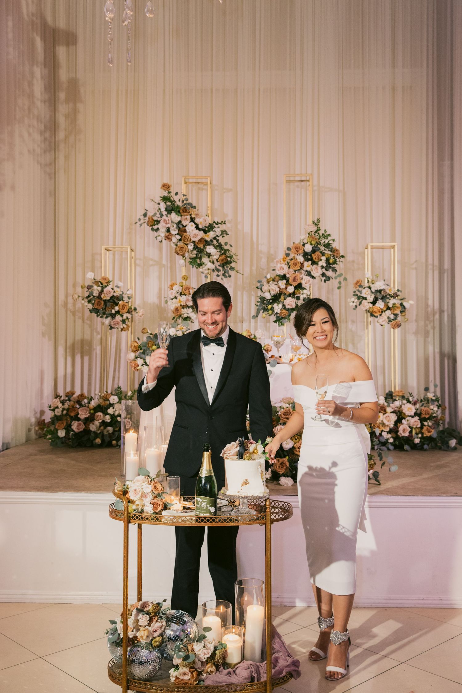 Elegant wedding reception setup with floral arrangements and gold decor elements.