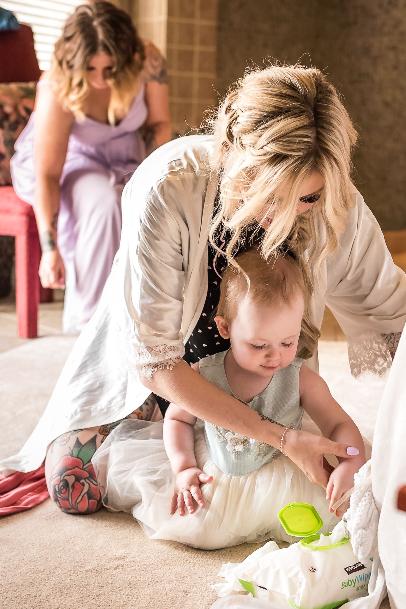 Bride helping flower girl get ready for wedding. Taken in Vancouver by Kari Mills Photography.