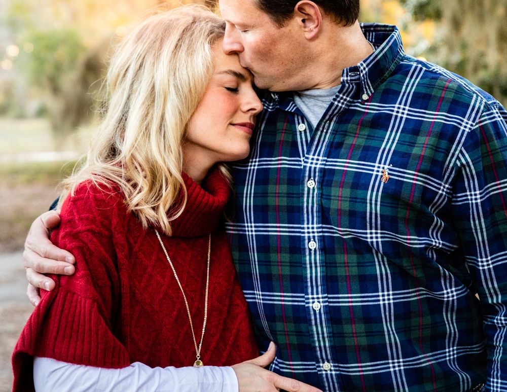 A tender moment as a loving husband kisses his wife on the head, expressing affection and care in a heartwarming gesture
