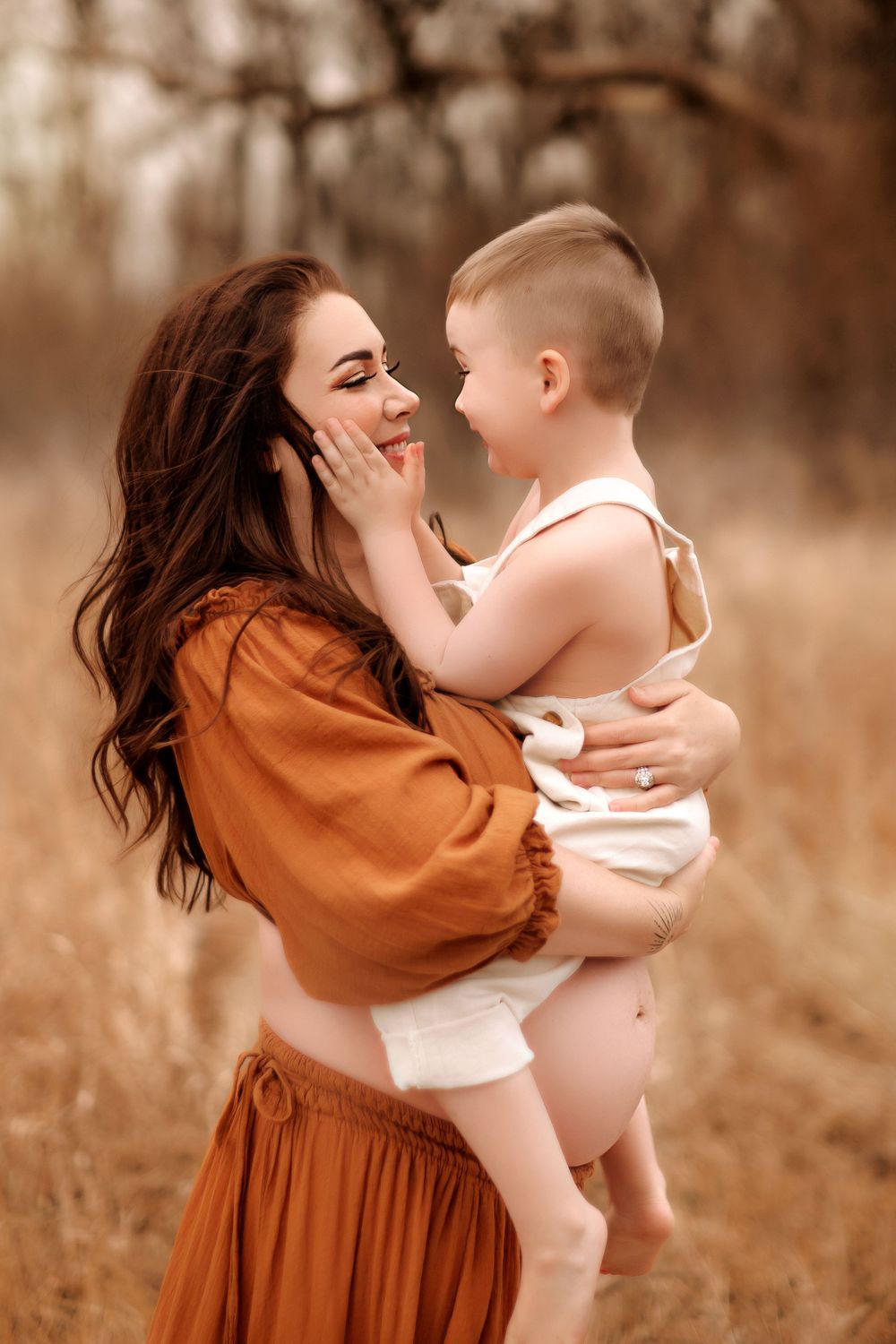 A tender moment captured between parent and child in an autumn-toned outdoor setting.
