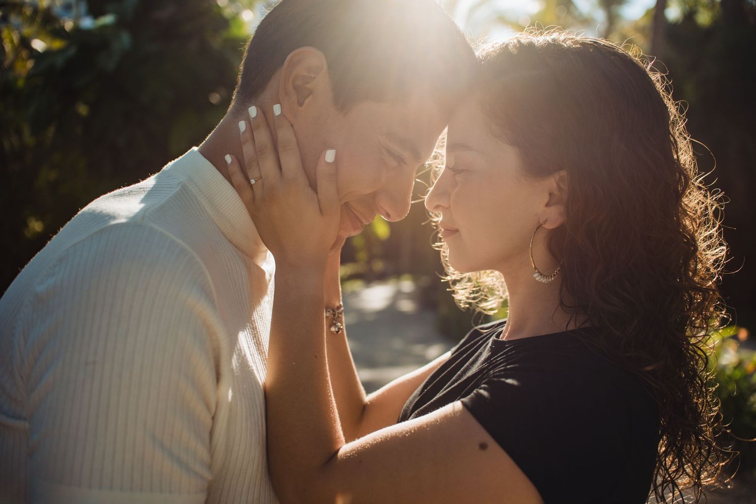 A tender romantic moment captured in warm sunlight with stunning lens flare.