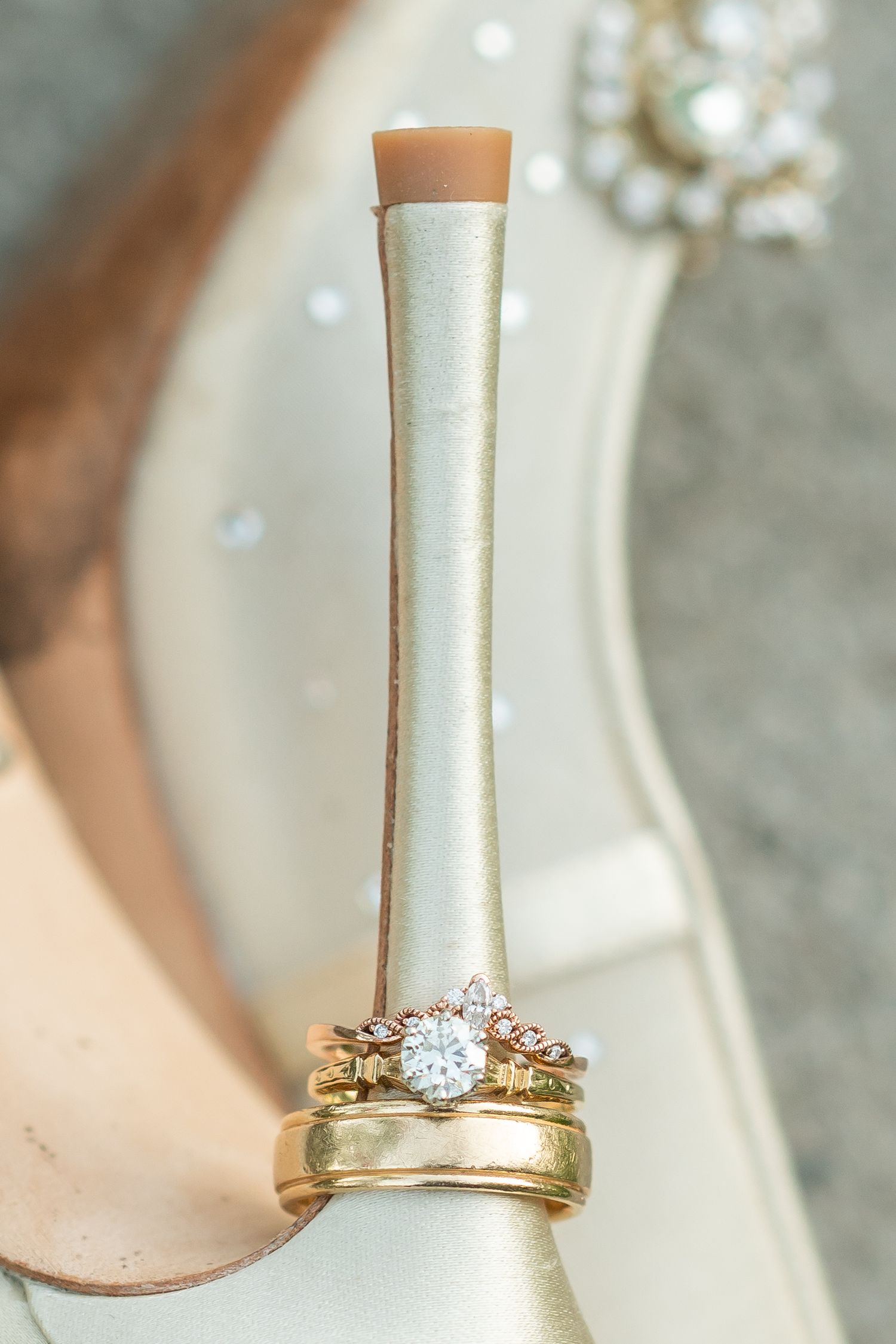 Close-up of engagement ring and wedding band set in rose gold against white background.