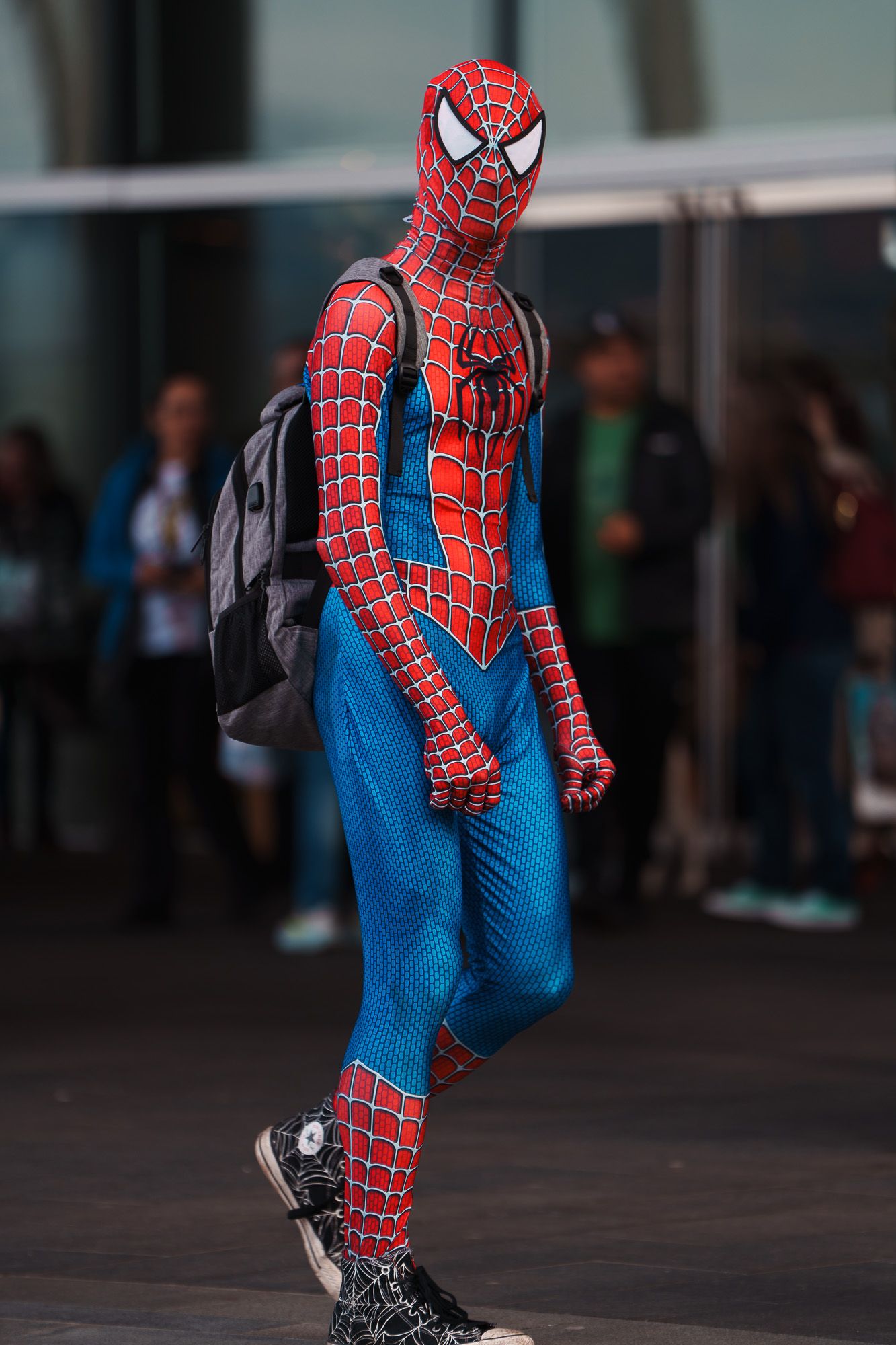 A man dressed in a full Spider-man cosplay, street photography.