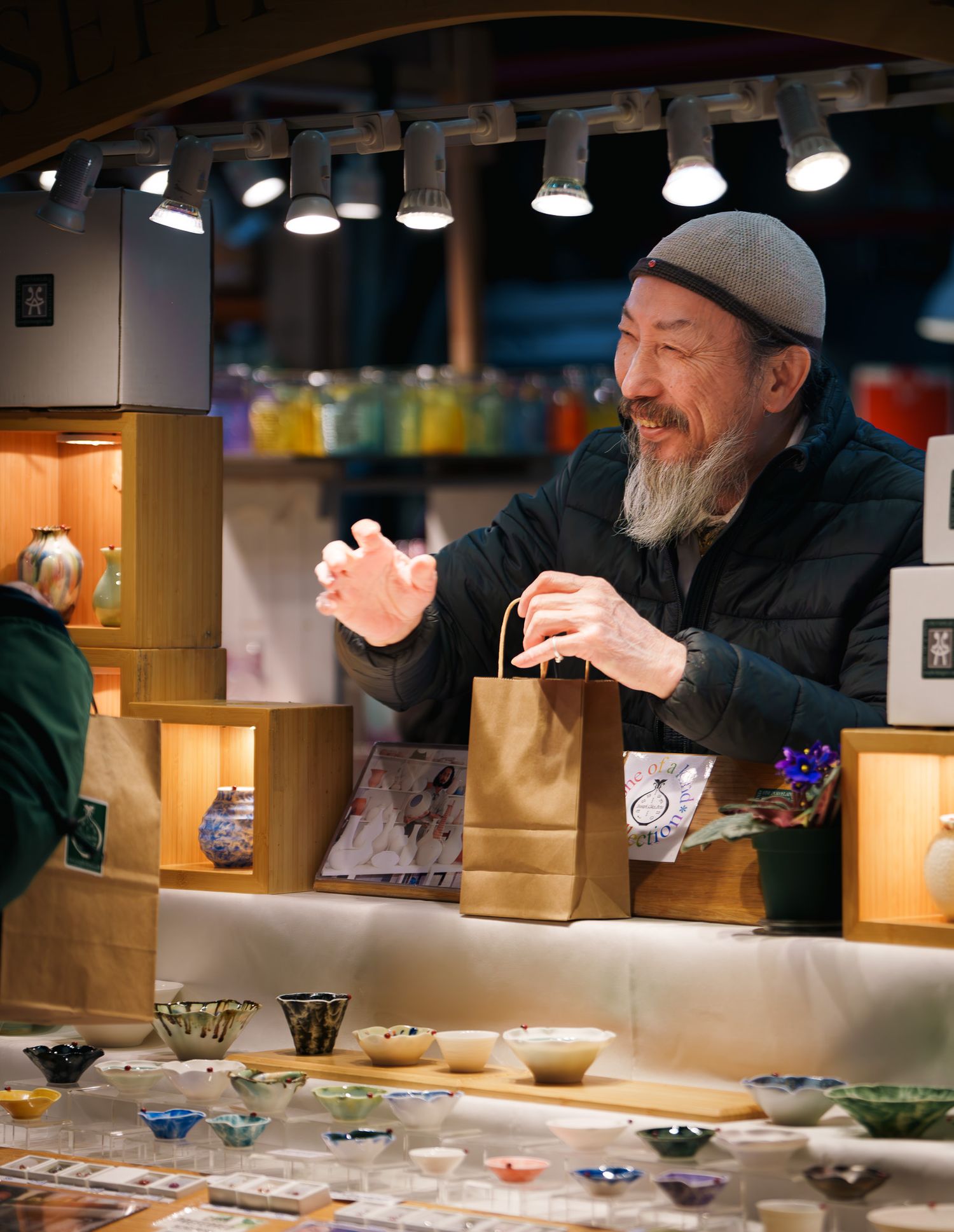A man handing his customer their merchandise, street photography.