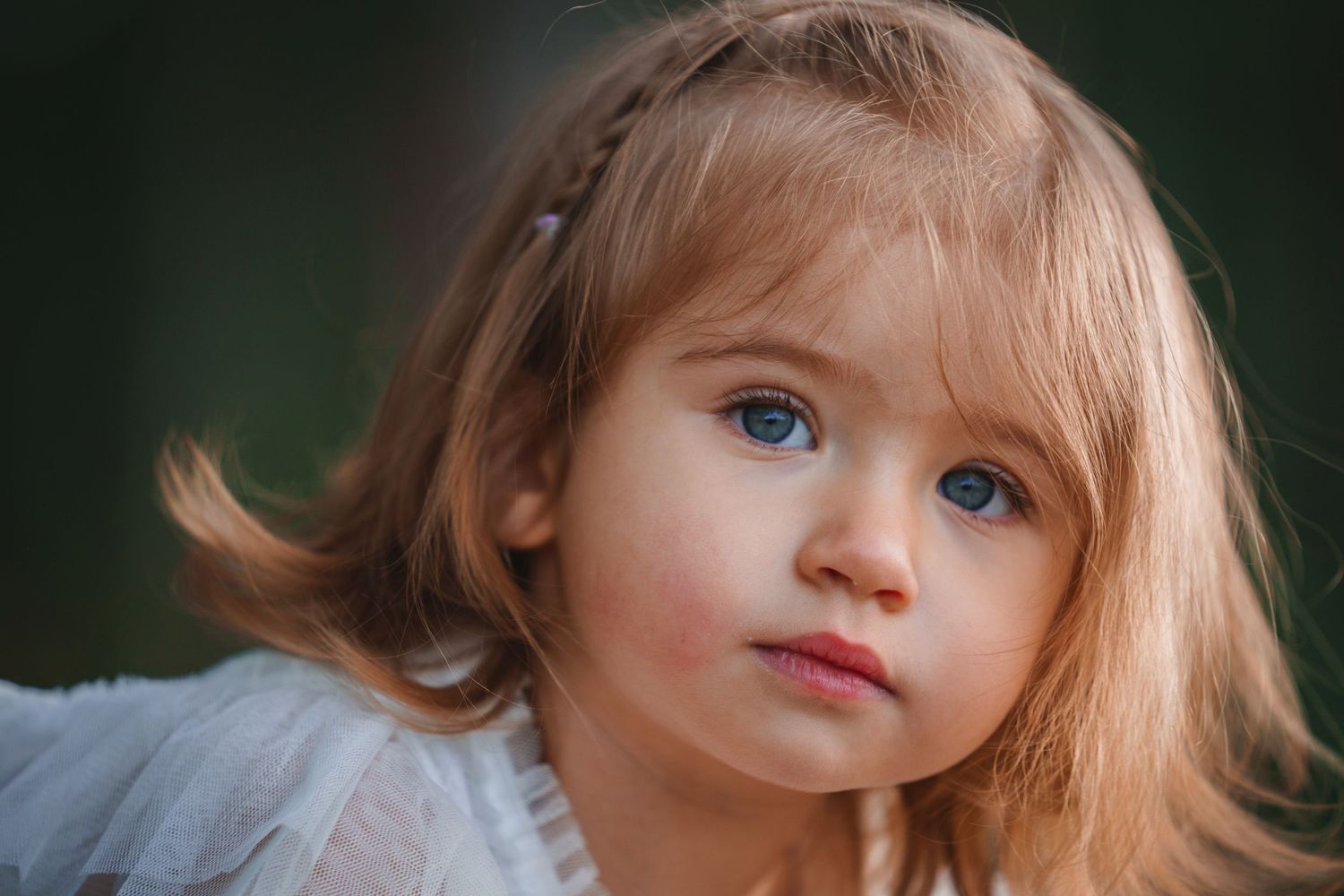 Close-up portrait of a young child with blonde hair and blue eyes.