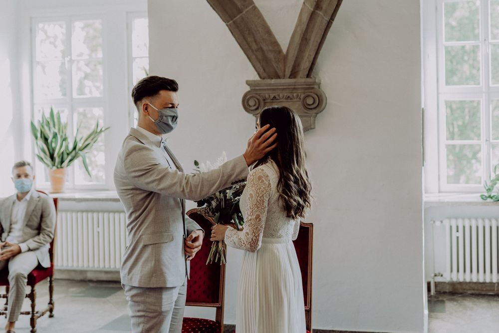 Wedding ceremony in a bright historic room with gothic architectural details.