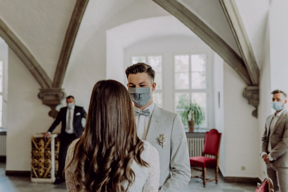 Wedding ceremony in elegant white room with vaulted ceilings and gothic architecture.