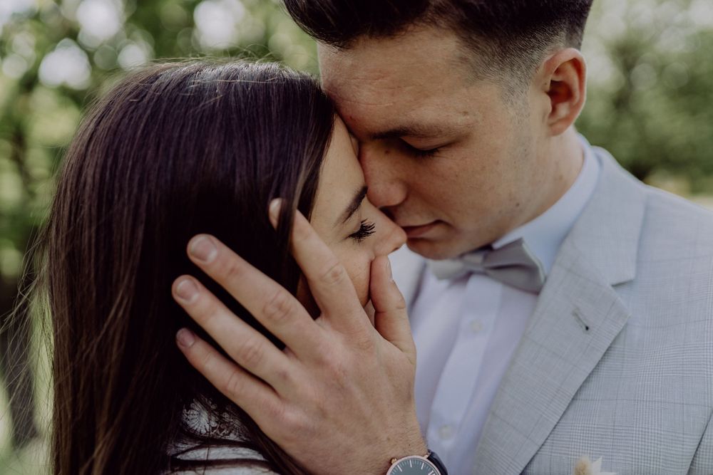 Close-up of a tender moment between couple during their outdoor wedding photoshoot.