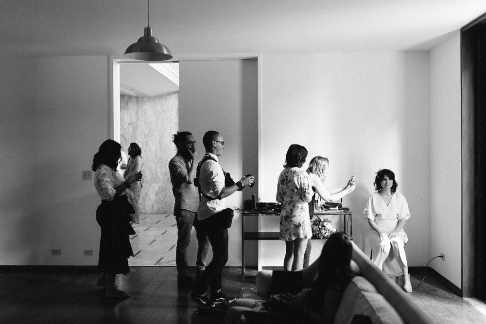 Black and white photo of wedding party getting ready in a bright room.
