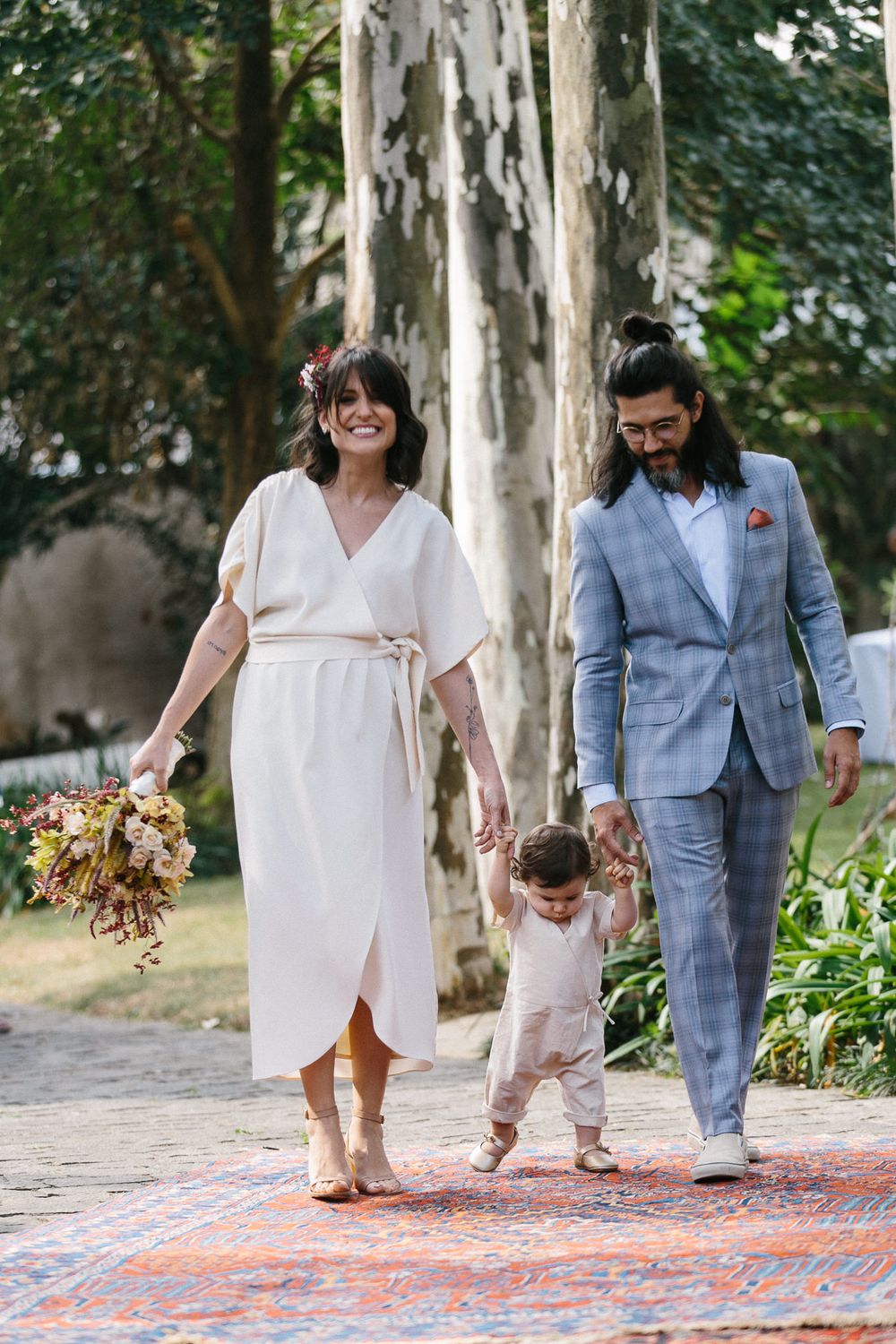 Family walking on a garden path decorated with a patterned rug.