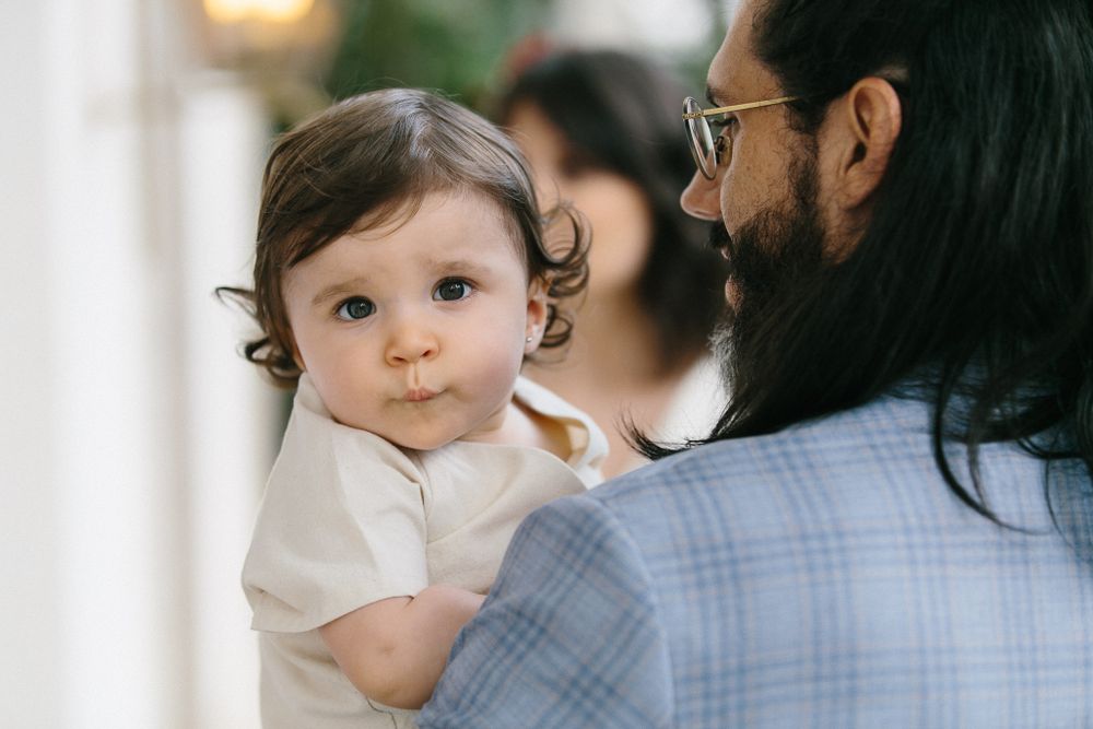 Close-up portrait of a toddler in white clothing.