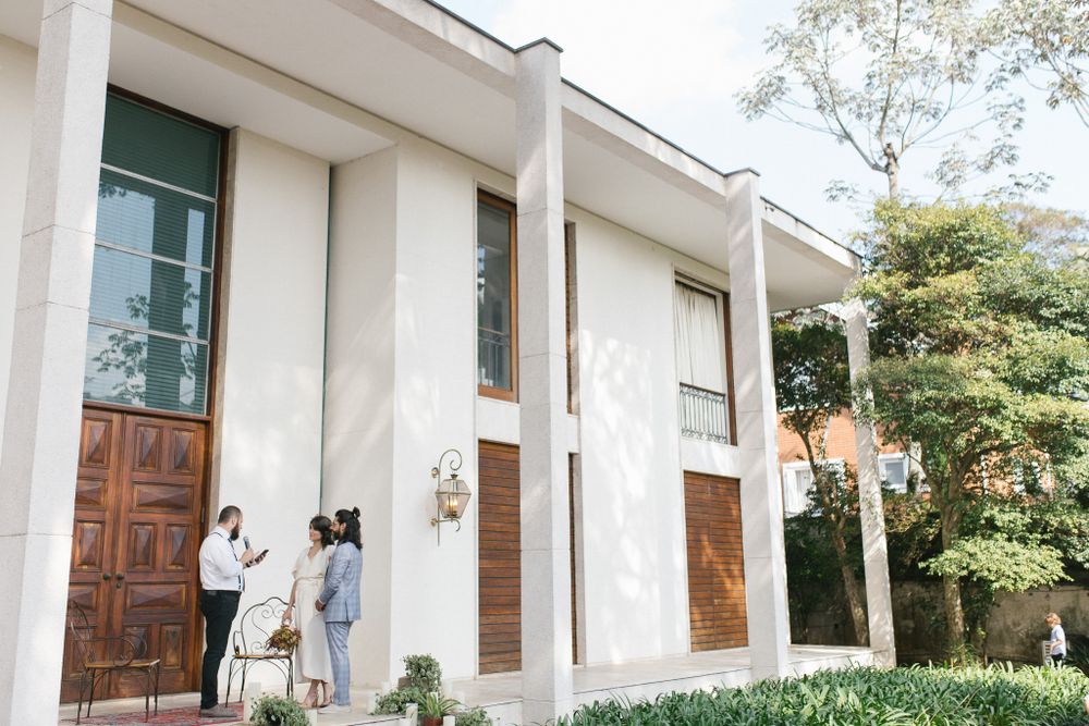 Modern white building exterior with wooden doors and columns in natural daylight.